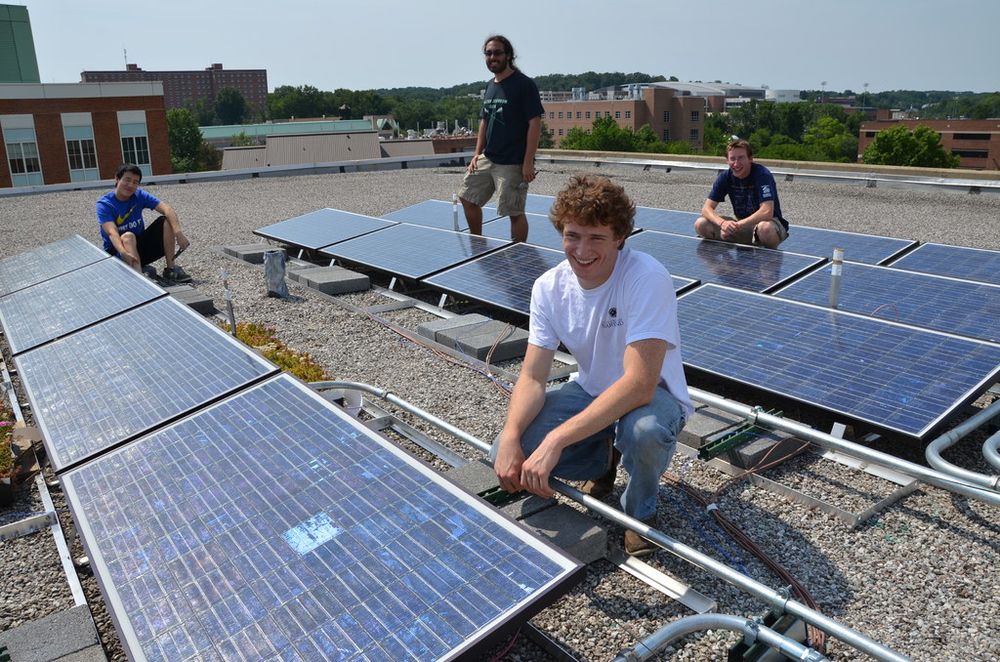 Installers checking rows of solar panels on a flat roof
